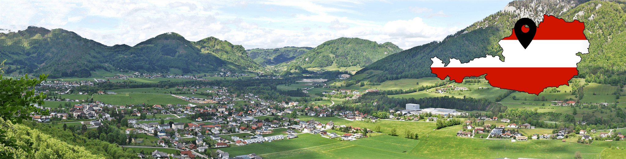 Panoramaansicht der Stadt Molln in Oberösterreich mit Bergen im Hintergrund. Rechts im Bild ist eine kleine Fahne in Form des Landes Österreich mit rot weiß roter Färbung und einem Pin, welcher auf die Koordinaten der Stadt zeigt.